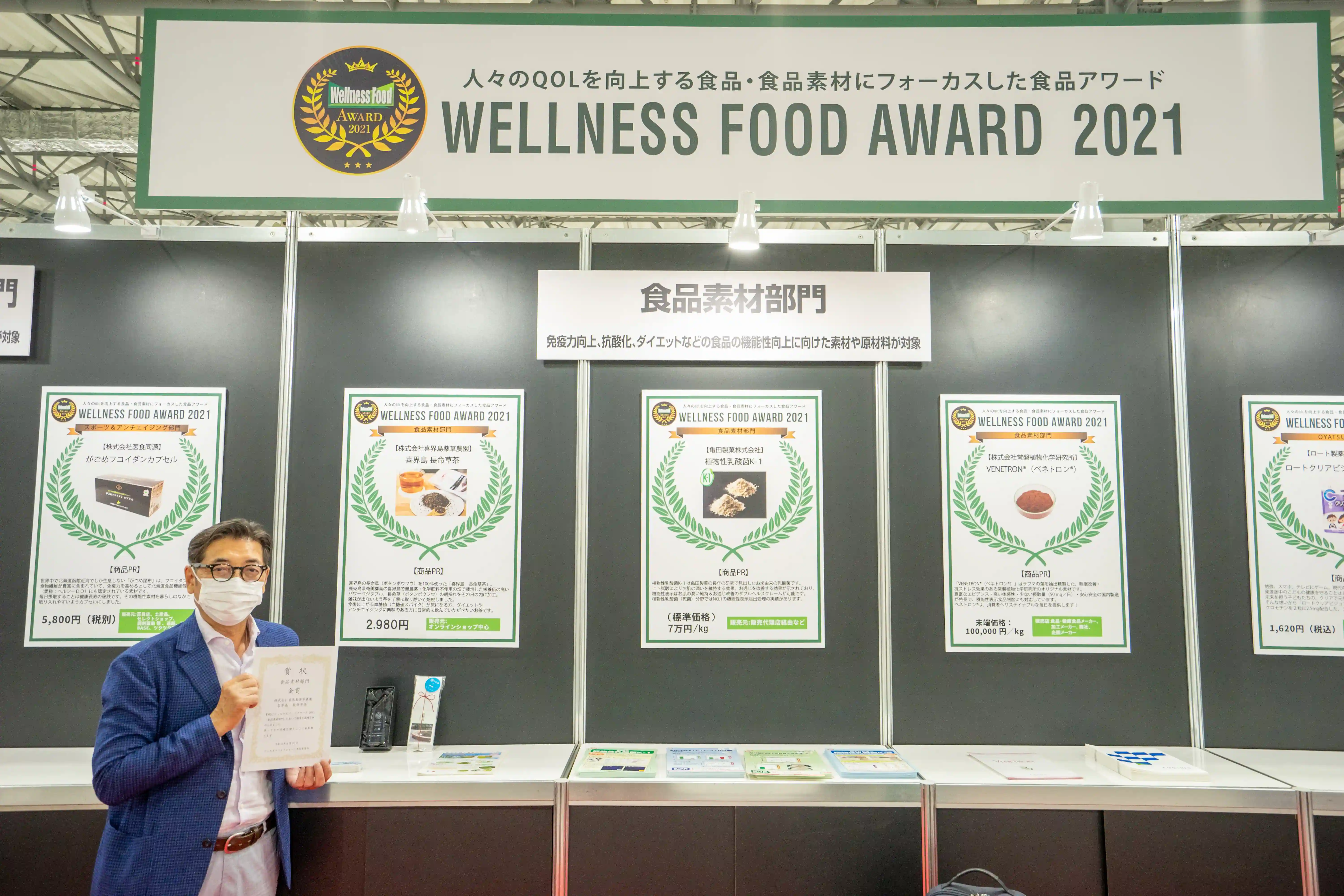「喜界島 長命草茶」ウェルネスフードアワード2021 食品素材部門　金賞パネルの前での代表