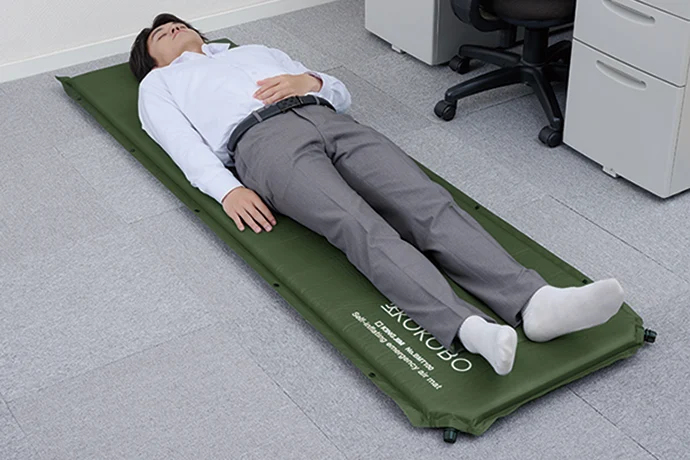 防災マットの上で仰向けになっている男性