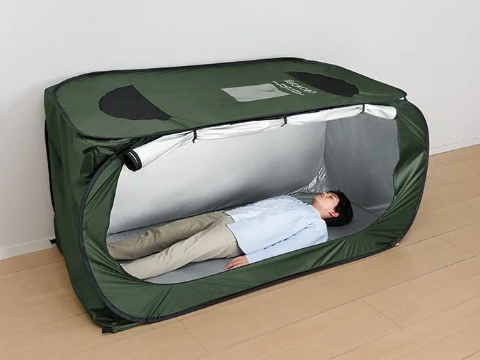 防災テントの中で仰向けになっている男性