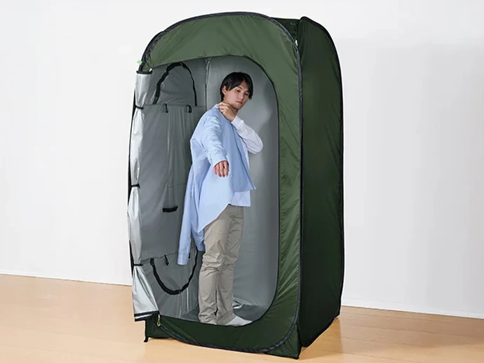 防災テントの中で着替えている男性