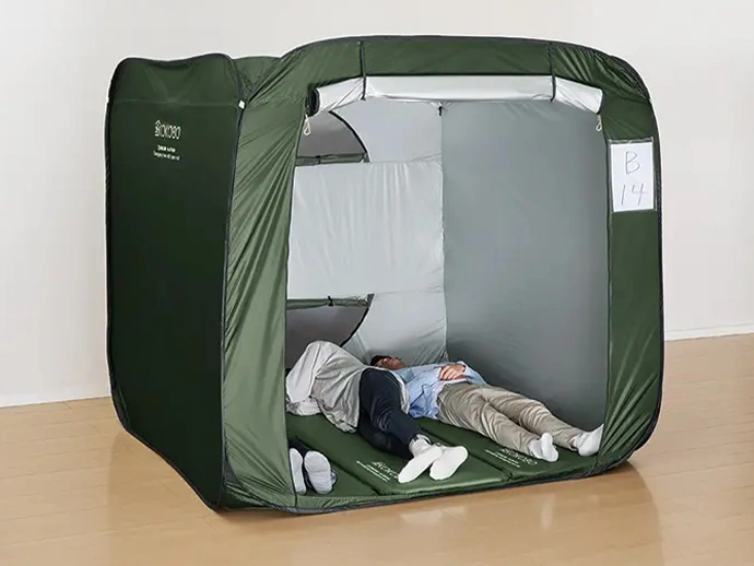 防災テントの中で着替えている男性