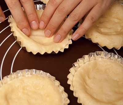 生地を型に入れて中央部をおさえる様子