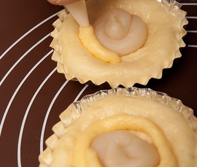 極上しろあんのまわりにカスタードクリームを絞る様子