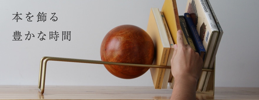 フレームにボールが転がり本を飾るslopebookend