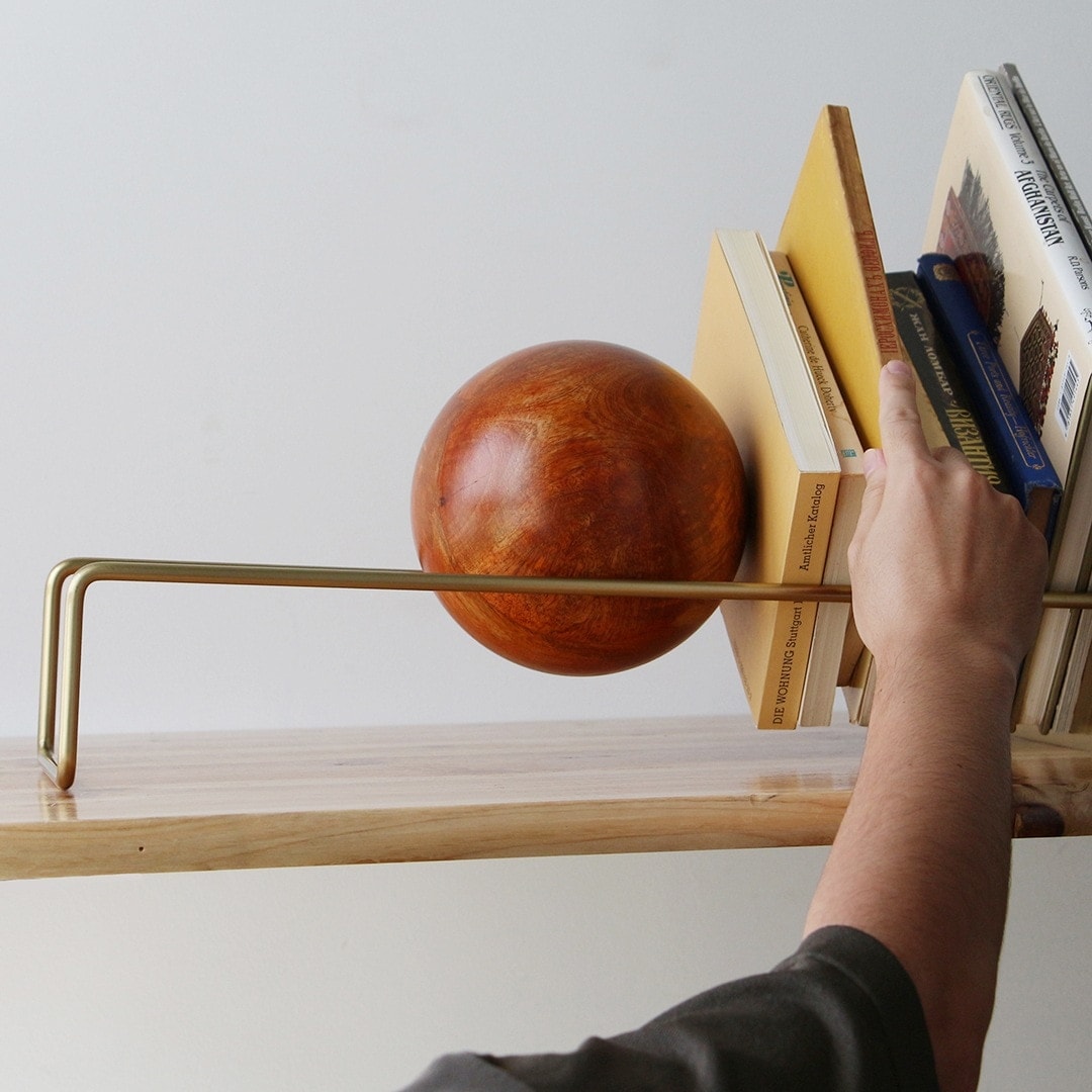 木のボールとフレームで本を飾るオブジェのようなスロープブックエンド
