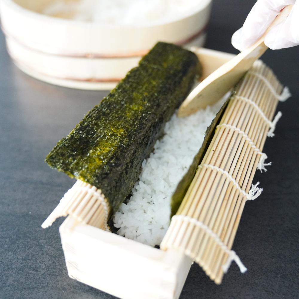 海苔・酢飯・具材を型に重ねるシーン