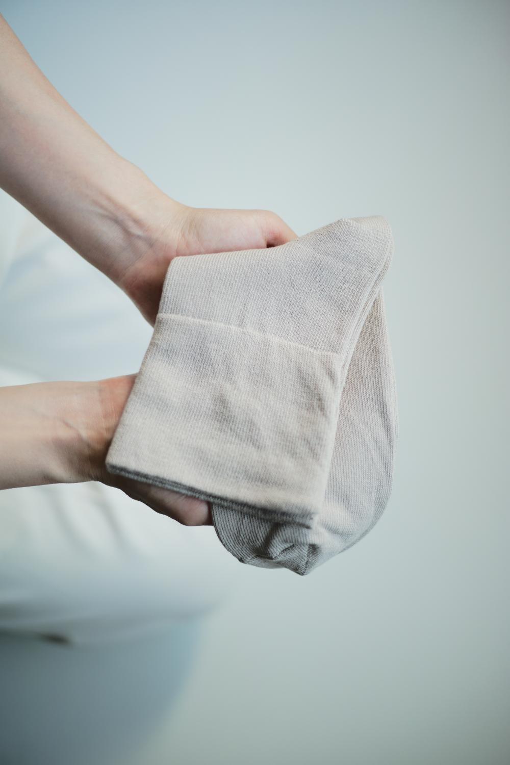 店主が大切に靴下を手に持つ様子