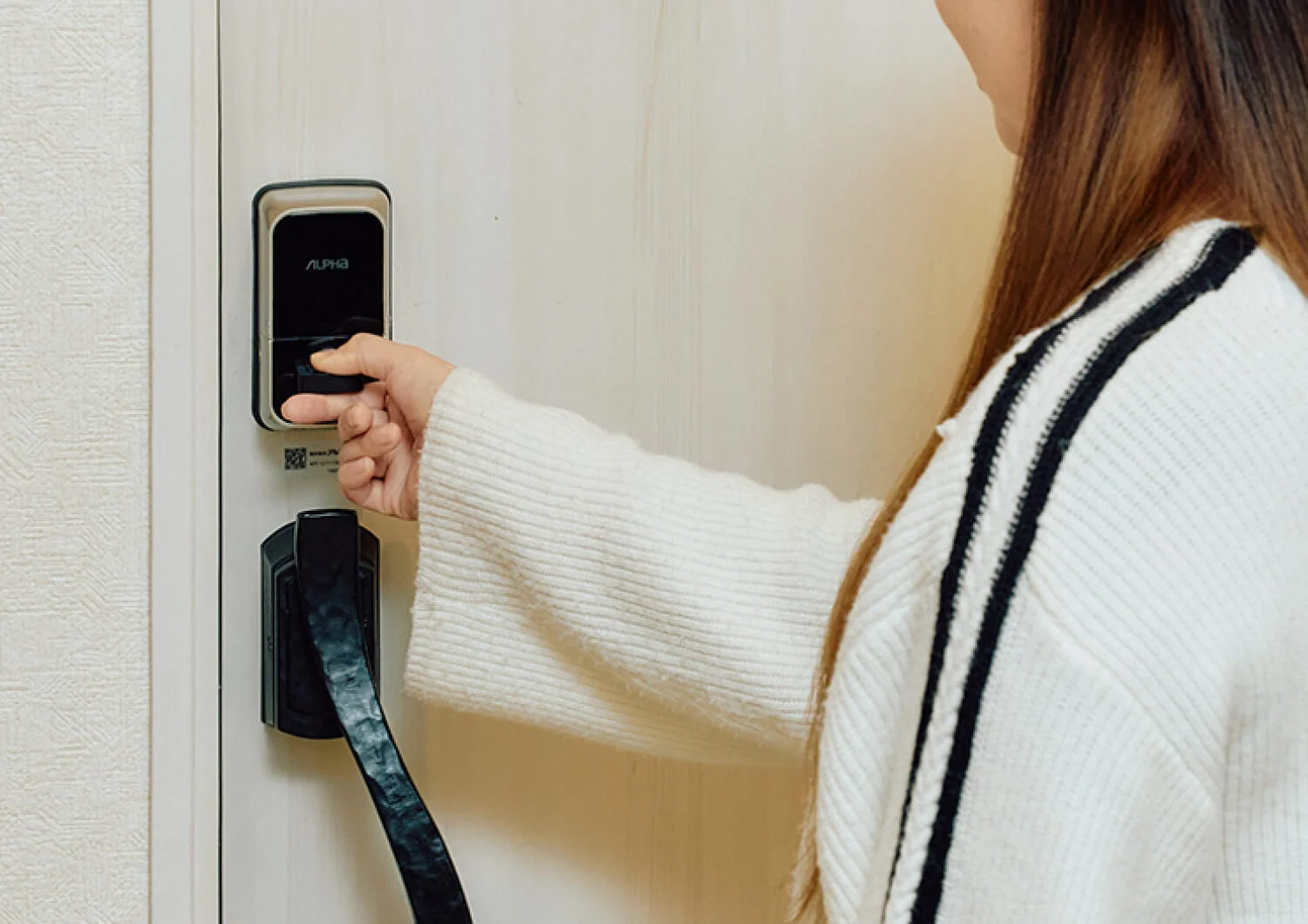 つまみのボタンを押しながら解錠する様子