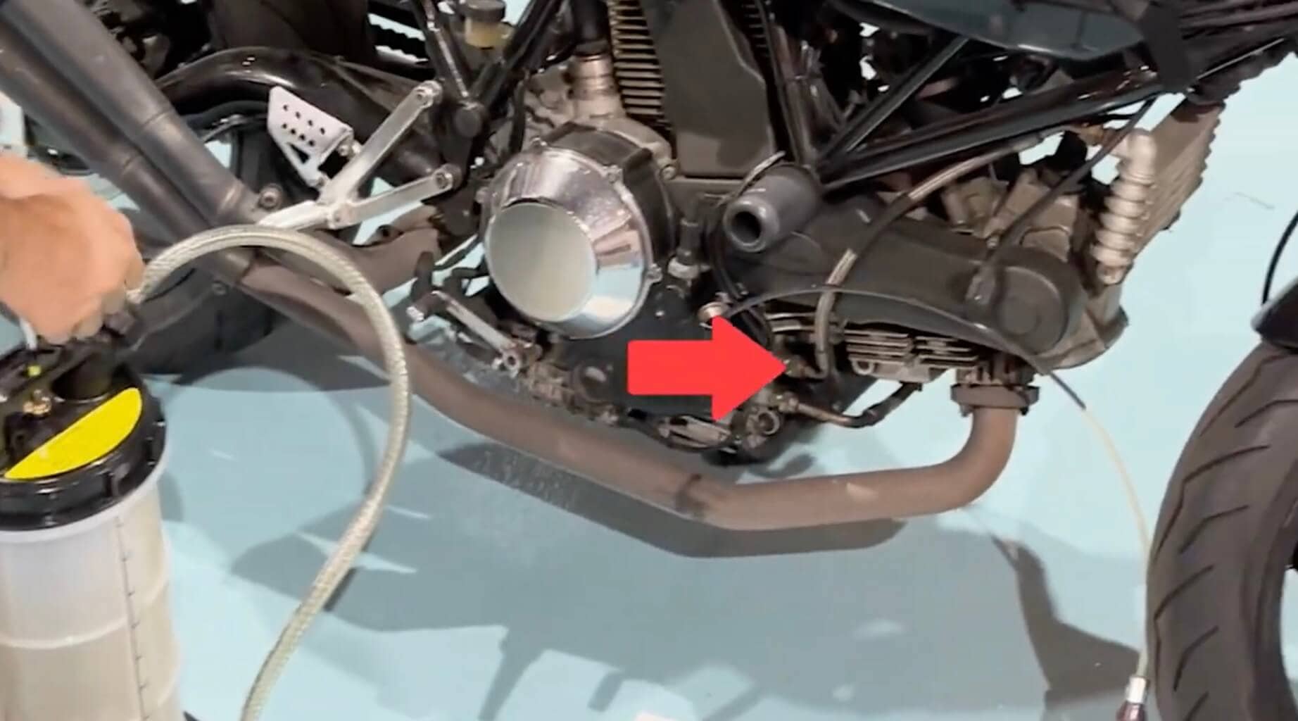バイクのエンジン部分をクローズアップした写真で、赤い矢印が特定の箇所を指している
