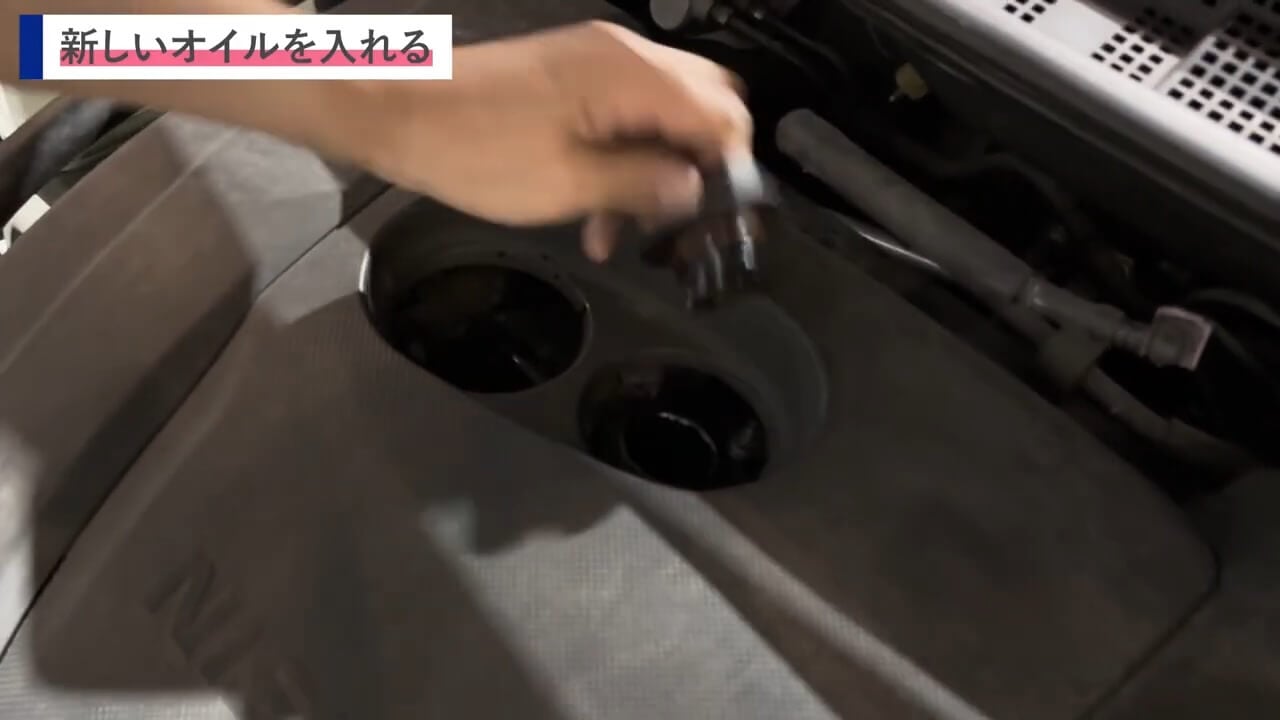 エンジンオイルキャップを開けるために手を伸ばしているクローズアップ