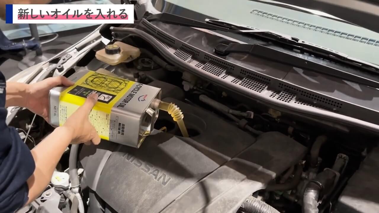新しいエンジンオイルを注ぎ入れる場面のクローズアップ
