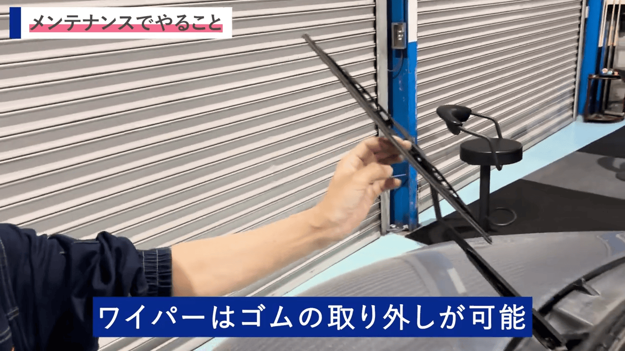 ワイパーを手に持ち、車両点検の一環としてワイパーの状態を確認している場面