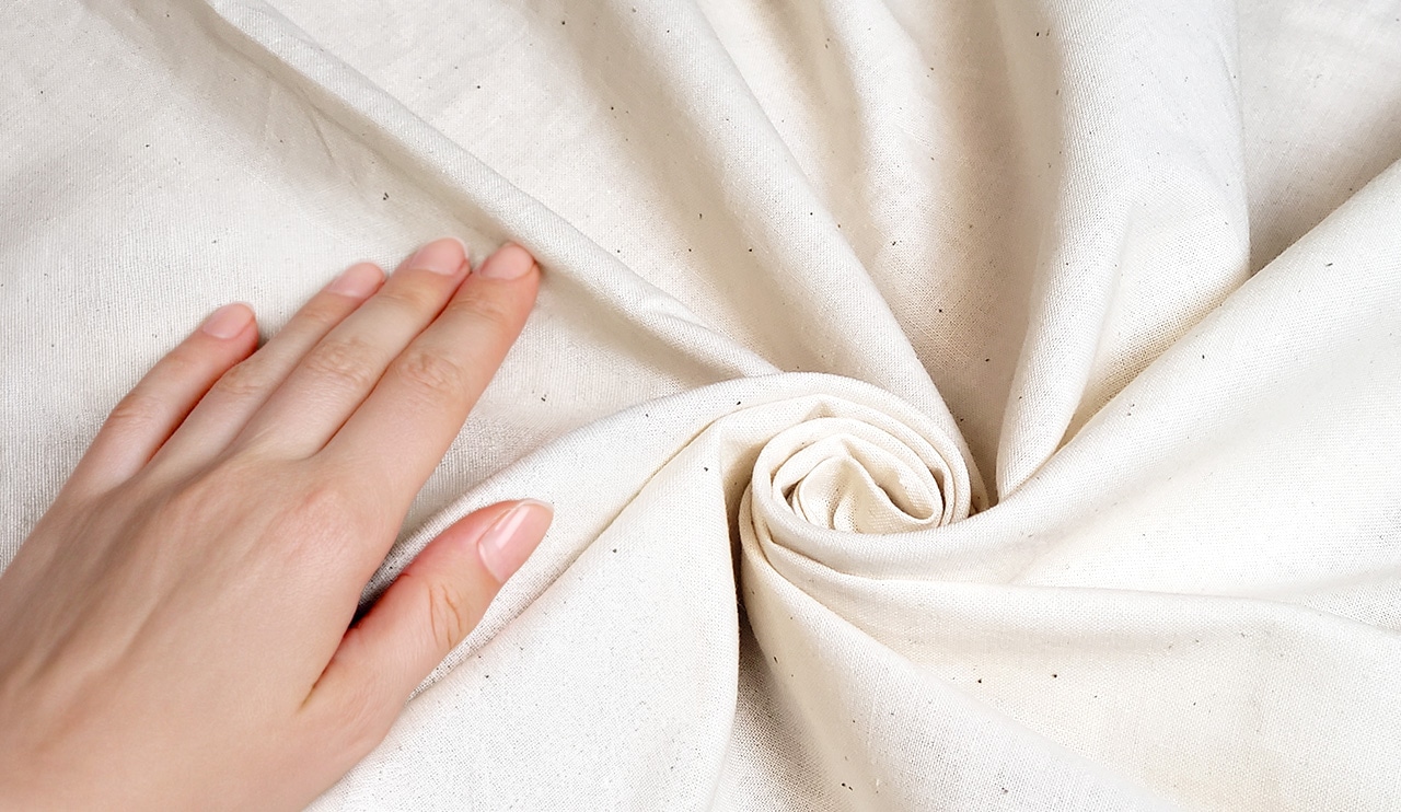 健康的な手とナチュラルなベッドリネン