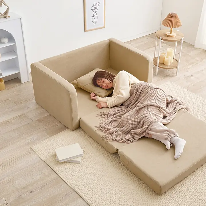 ワンルームで、広げたソファベッドにブランケットを掛けて眠る様子
