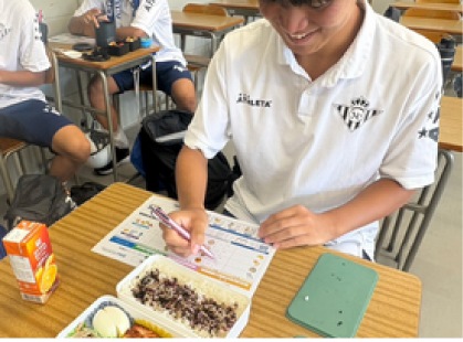 学校で記録をつけるアスリートの様子