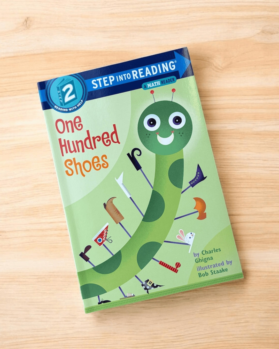 ハードカバー英語絵本"One hundred shoes" の表紙　© 2002 by Charles Ghigna.