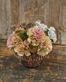 ココア色のバスケットに華やかなフラワーアレンジメント