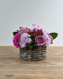 グレイのバスケットにパープルのフラワーアレンジメント