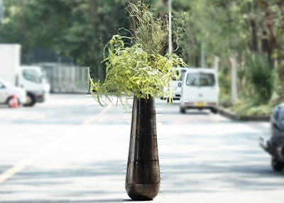 大きめのブラックのアルミニウム製フラワーベースに枝物が生けてある使用イメージ