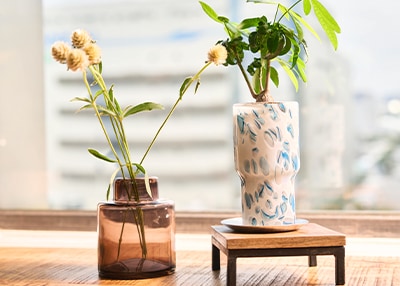 ブラウンのフラワーベースが窓際の光を透過させている使用イメージ