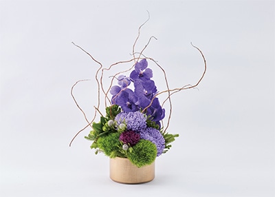 ゴールドな鉄製鉢に華やかなフラワーアレンジメント