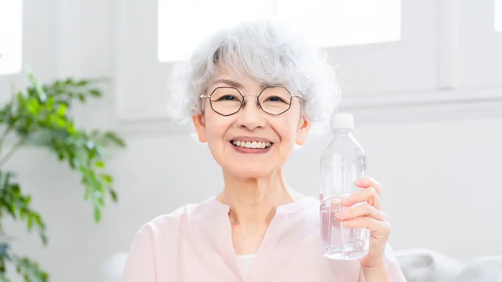 水分補給をする高齢女性の画像