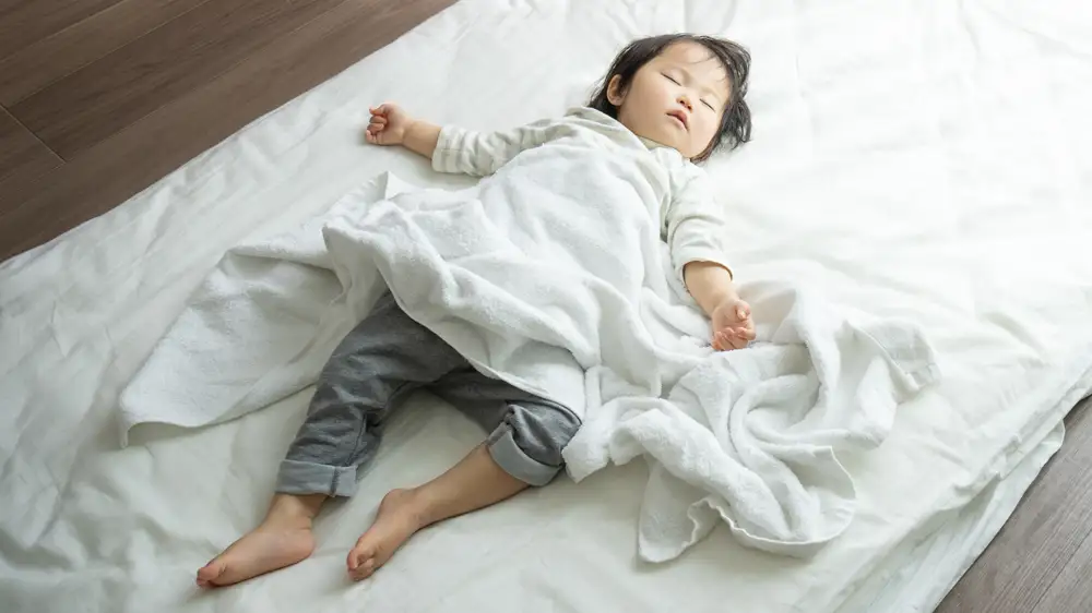 お昼寝をするこどもの画像