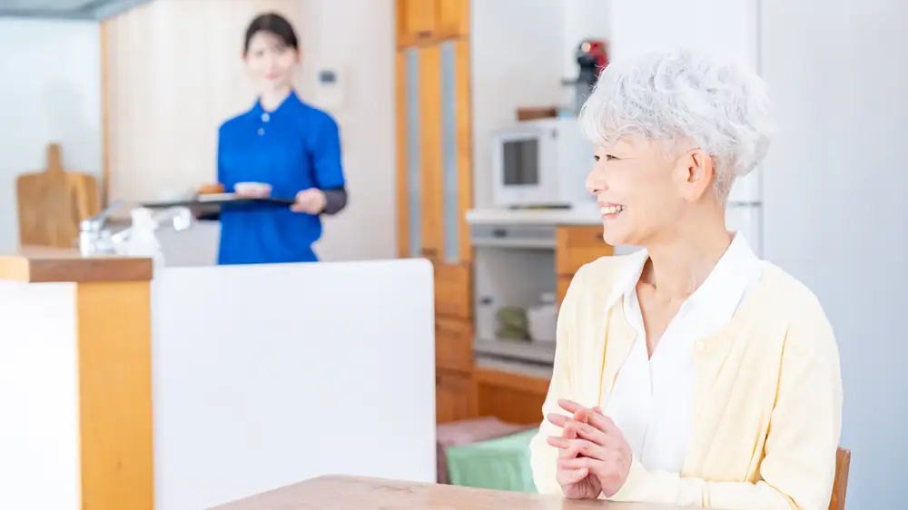 家事を手伝ってもらい豊かに暮らす高齢女性の画像