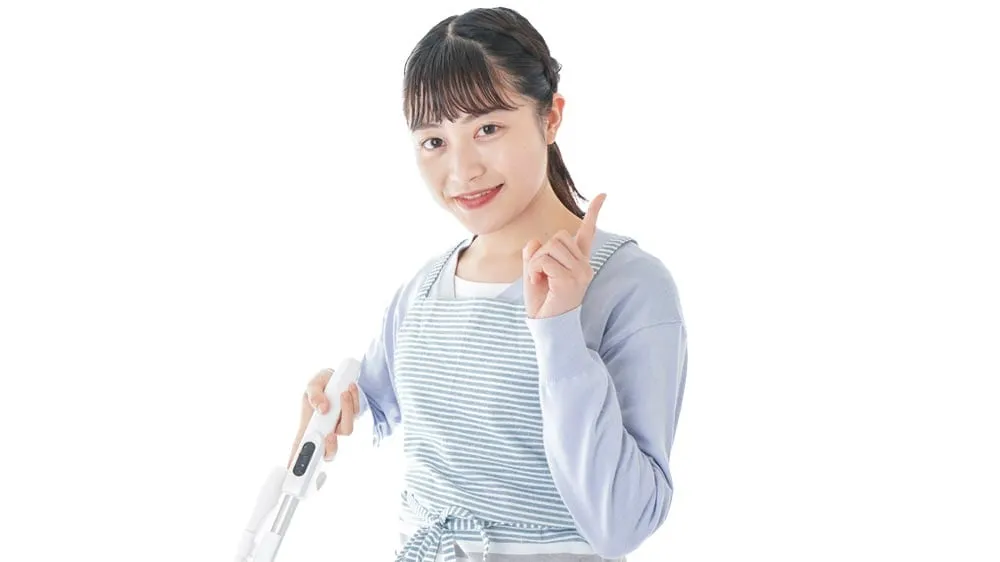 掃除道具を持っておる女性の写真