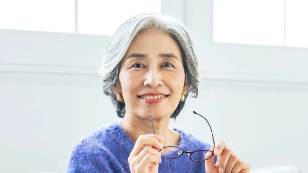 老眼鏡を持つ女性の画像