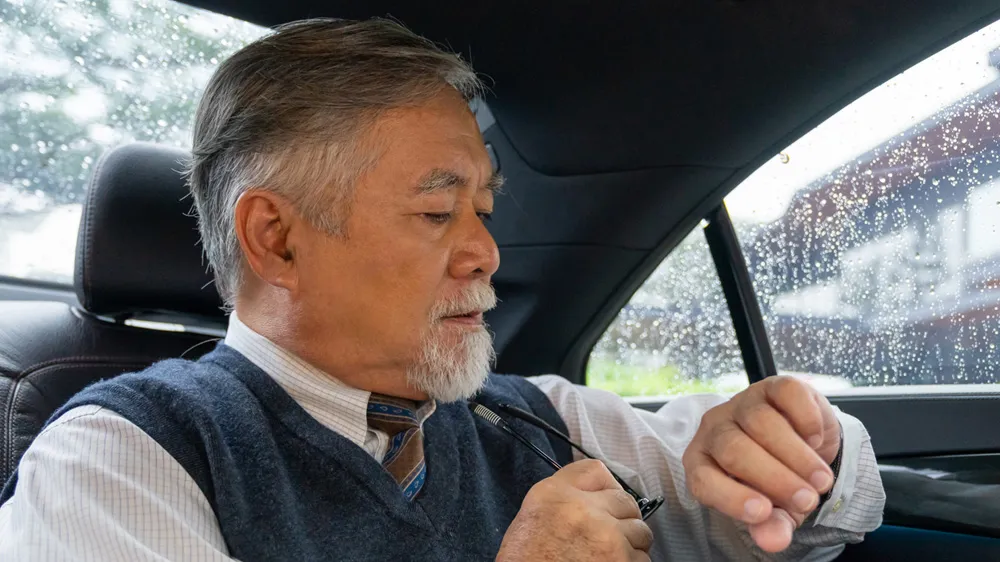 スマートウォッチの電卓機能で計算する男性の画像