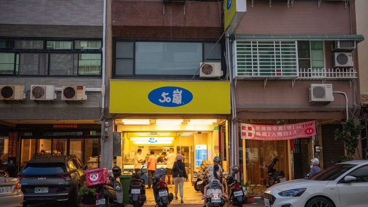 台南・德興路にある50嵐の創始店。夜の店頭に黄色い看板と楕円のロゴが掲げられている