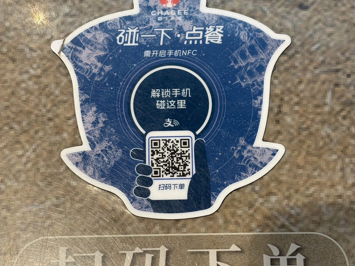 上海のCHAGEE店舗のテーブルに貼られた注文用のシール。「碰一下・点餐」（かざして注文）の文字とNFCのマーク、QRコードが印刷されている