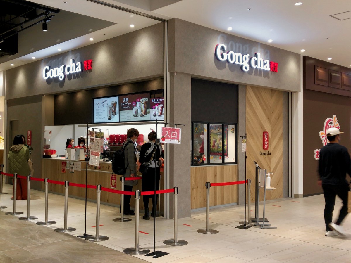 愛知県春日井市のイーアス春日井にあるゴンチャの店。白い壁にGong cha 貢茶の看板があり、注文カウンターの前に列を仕切るポールが並ぶ