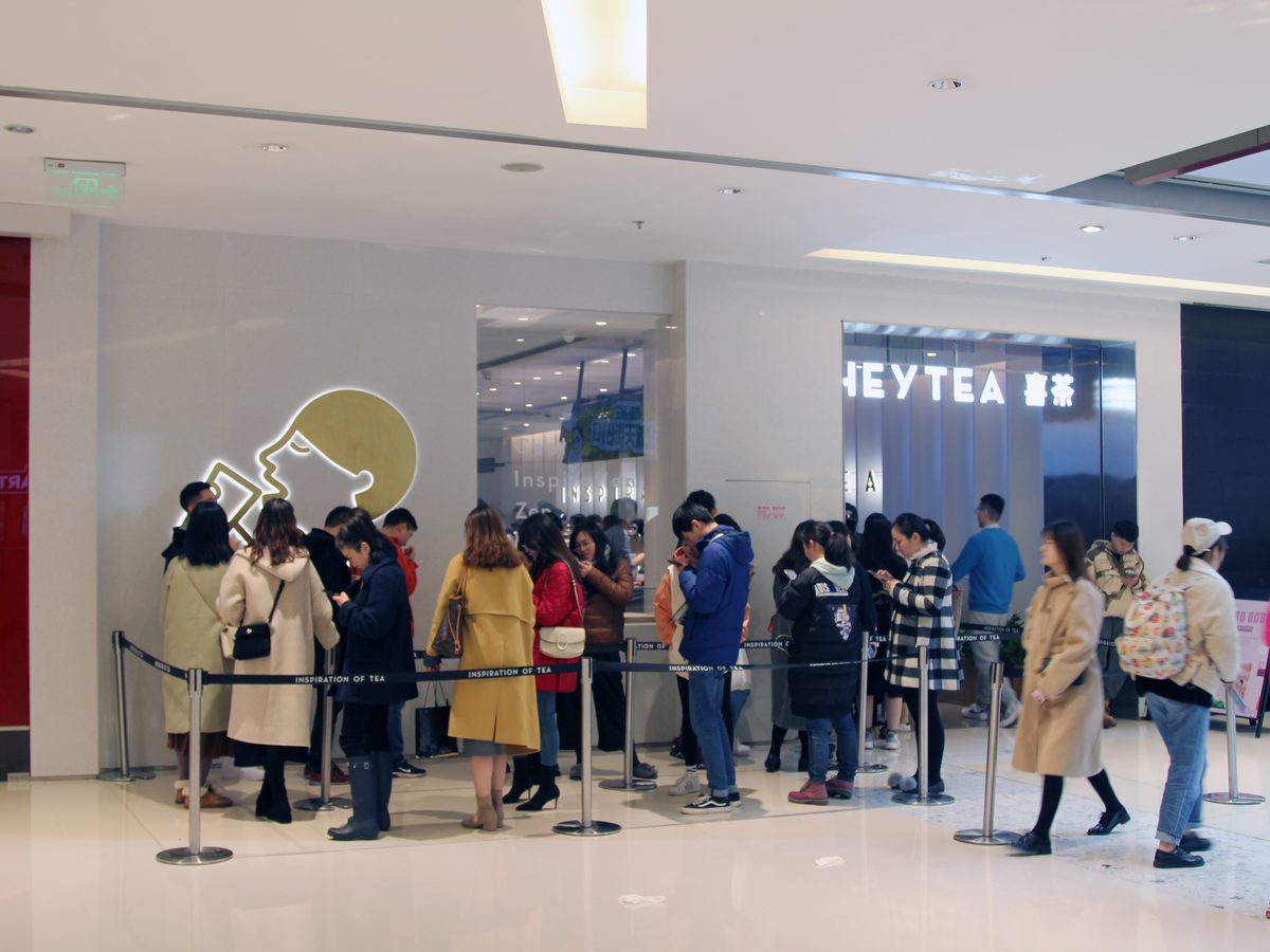 2018年、中国・重慶の商業施設にあるHEYTEA店舗前で、仕切りのポールに沿って数十人が列を作っている
