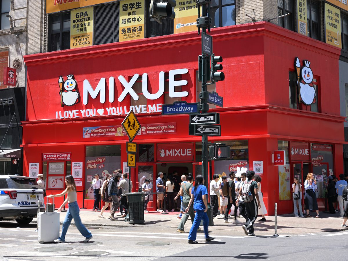 ニューヨーク・ブロードウェイの角に構えた蜜雪氷城(MIXUE)の赤い店舗。看板にロゴとマスコットの雪王