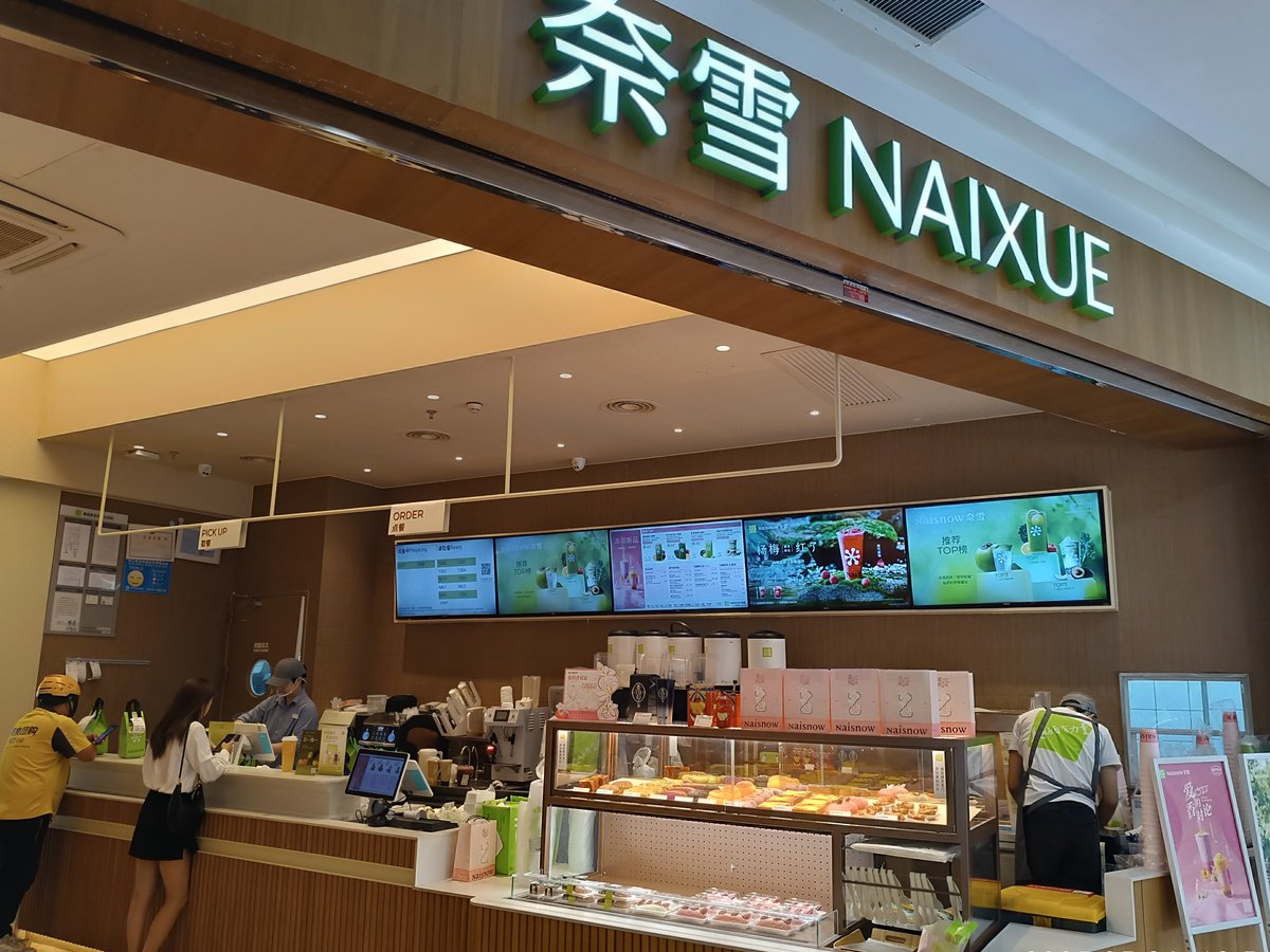 中国・深圳市の商業施設にある奈雪(NAIXUE)の店舗。緑の奈雪 NAIXUEの看板と焼き菓子のショーケース