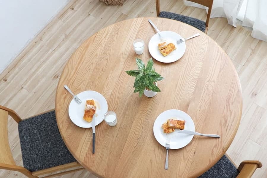 円形ダイニングテーブルを真上から見た、3人分の食事を並べた様子