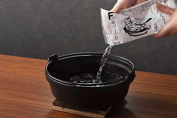 専用の「うれしの温泉 湯どうふ用 調理水」を鍋に入れ、豆腐を入れ沸騰させる。（※かならず専用の調理水をご使用ください。）