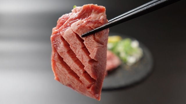箸で持ち上げられた新鮮な肉