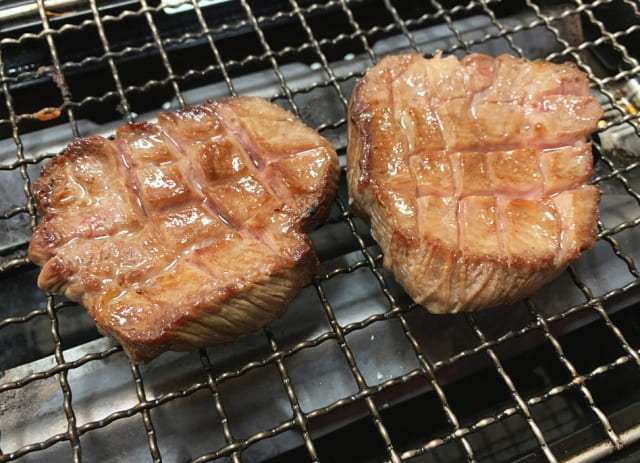 焼き網で焼かれている厚切り肉