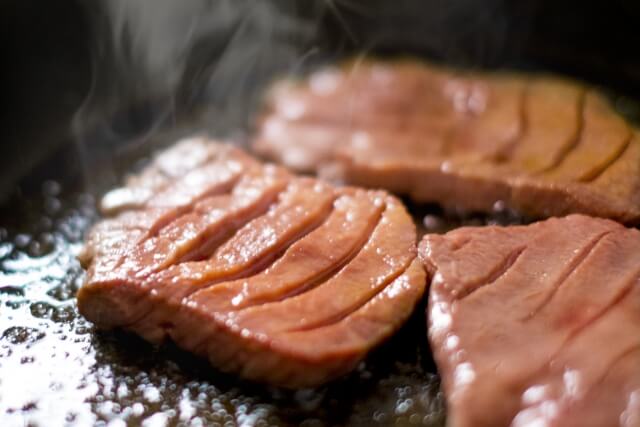 フライパンで焼かれる鮭の切り身