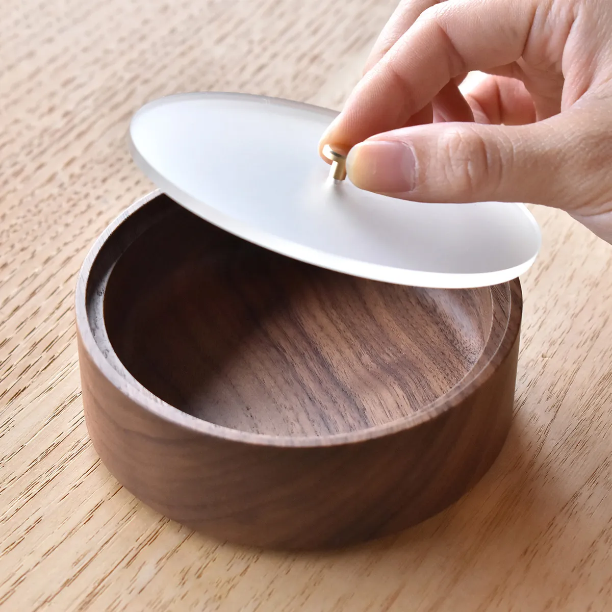 アクリル蓋付きの小物入れ。つまみは真鍮を使用しており、木の温もりにラグジュアリーさをプラス。