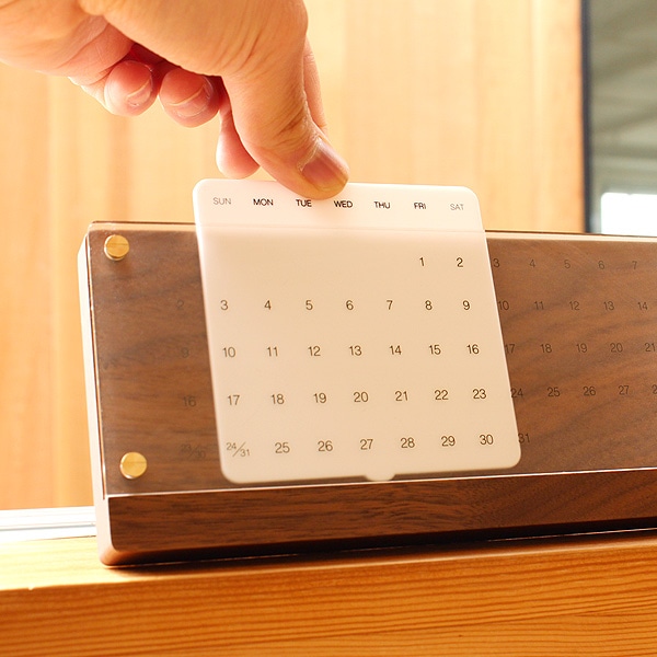 白板をスライドさせて使用します。簡単な動作で永く使える木製万年カレンダー