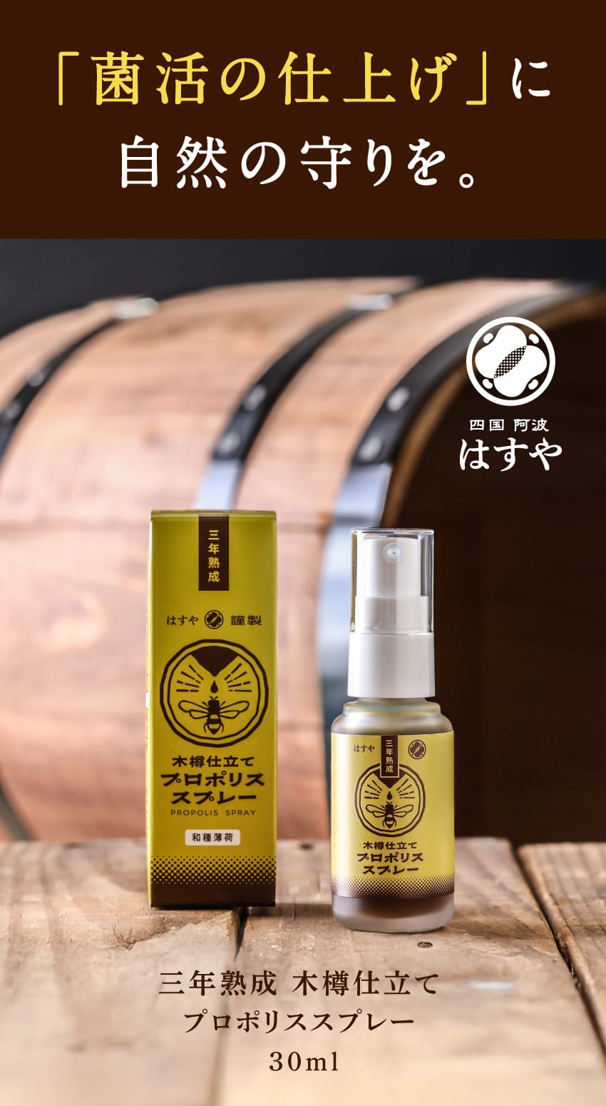 菌活の仕上げに自然の守りを。四国 阿波 はすや。三年熟成 木樽仕立て プロポリススプレー 30ml。和種薄荷。木樽を背景に、商品の箱とボトルが置かれています。