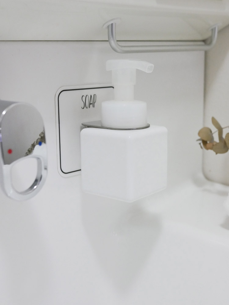 白色のOtelボトルホルダーが浴室の壁に設置されている