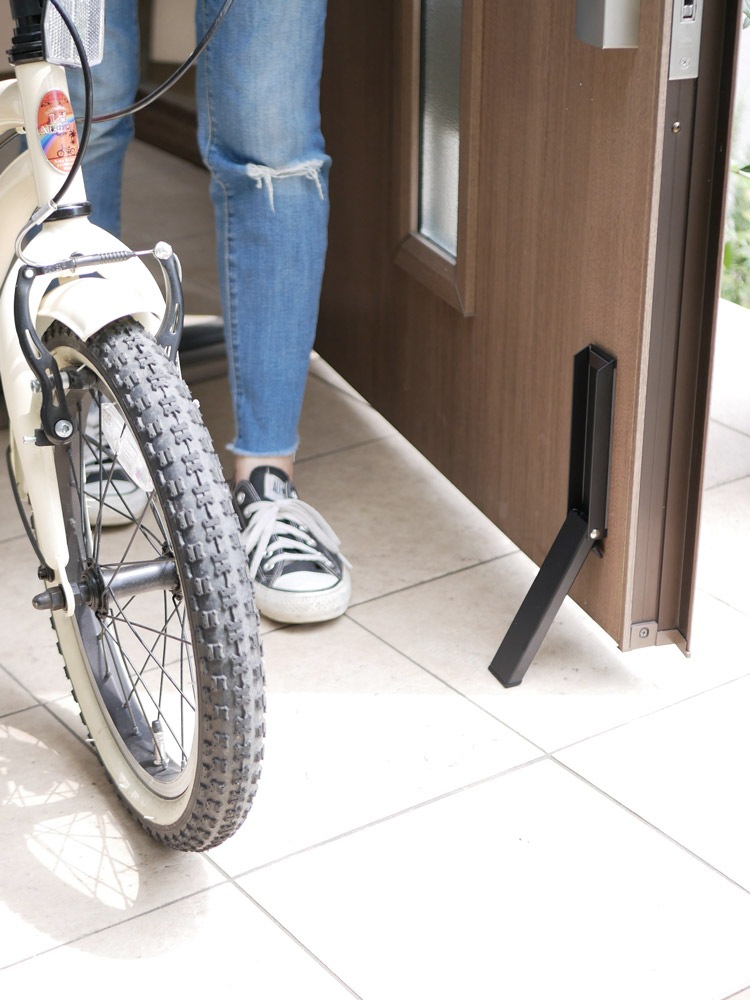 スチール製のマグネット付き折り畳みドアストッパーがスチール製ドアにしっかりと取り付けられている様子。