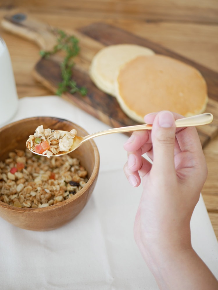 SALUS（セイラス）のエレガンテシリーズ、18-10ステンレスゴールド製のスプーンやフォークなどのカトラリーが整然とテーブルに並べられている様子