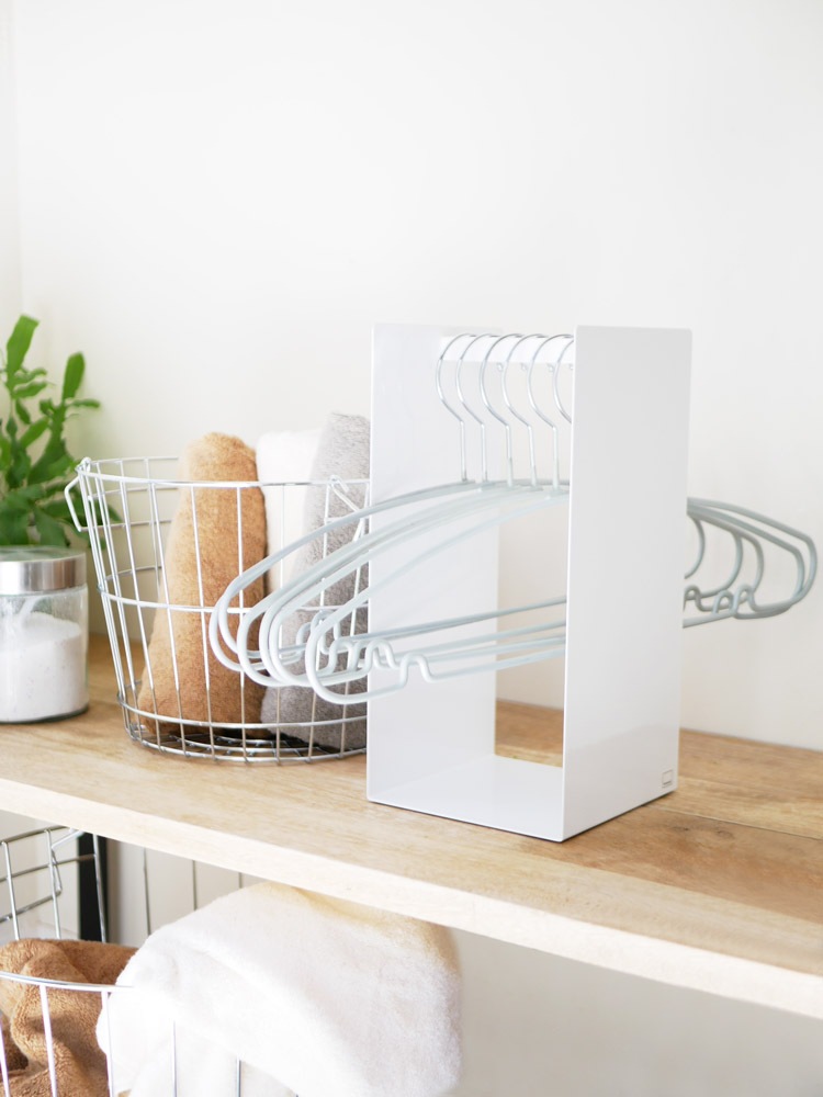 タワー製スチールハンガー収納ラックにハンガーが掛かっている