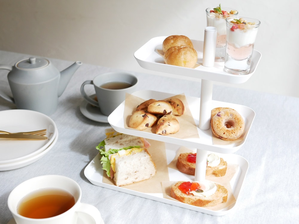 towerブランドのキッチン3段トレーに食器とカップが並んでいる